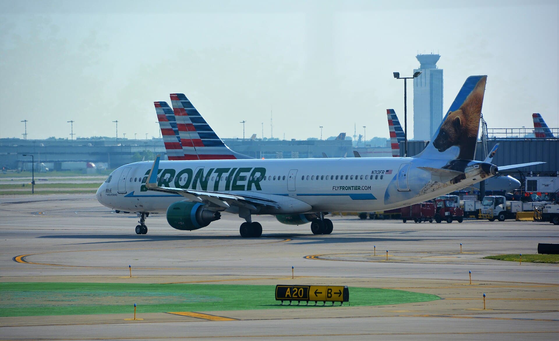 Frontier A321 with a wolverine tail taxiing at Chicago O'Hare past a row of American tails